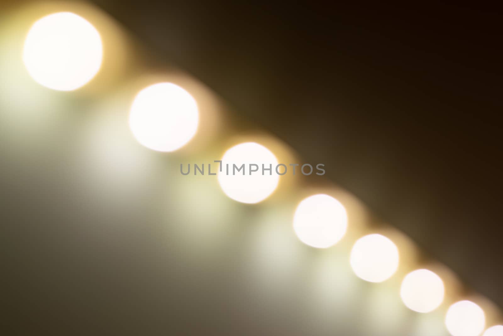 Blurry warm lights bokeh seen from a diagonal perspective.