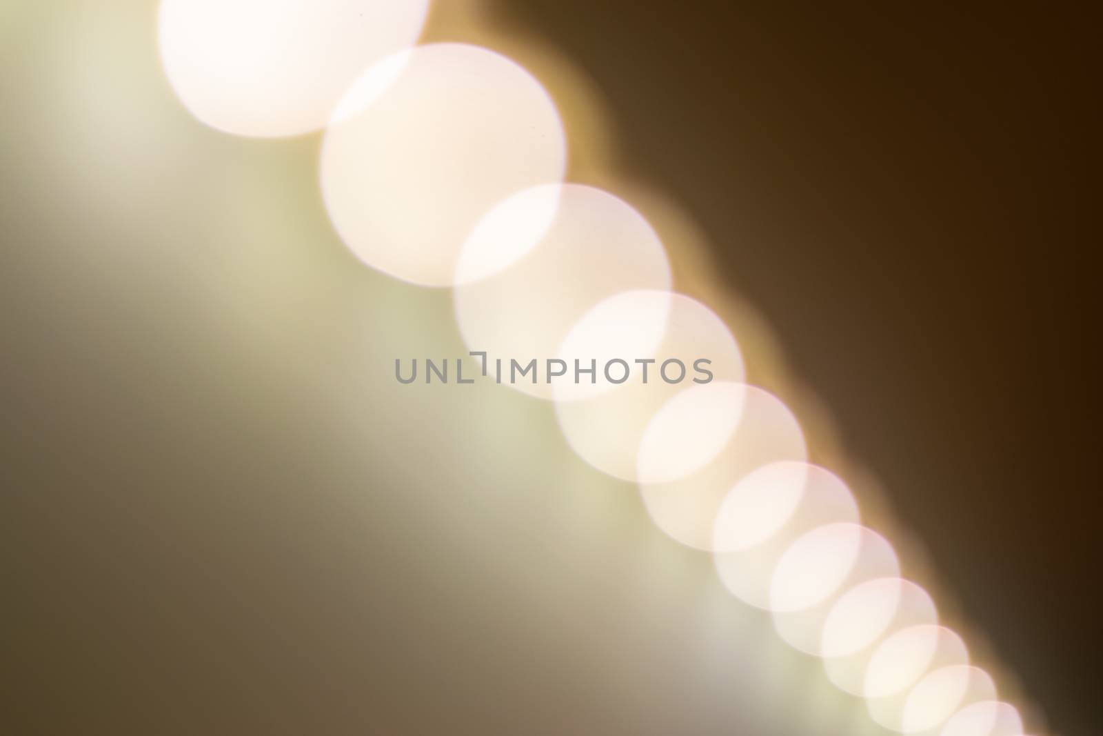 Blurry warm lights bokeh seen from a diagonal perspective.