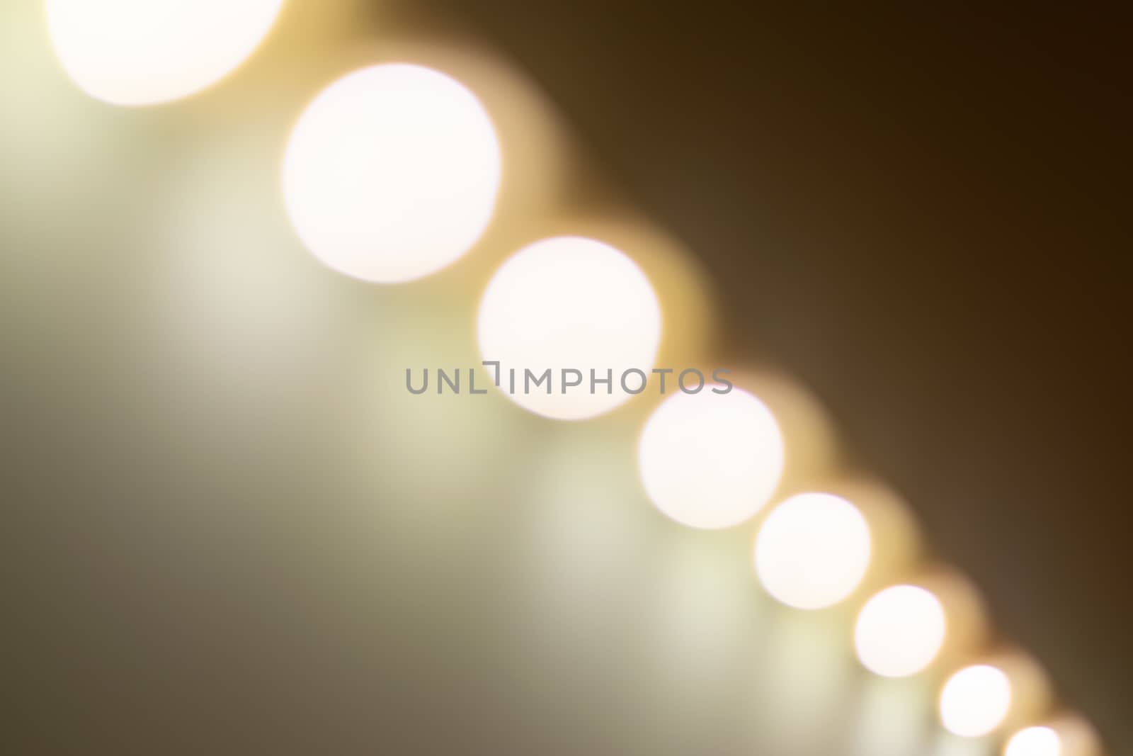 Blurry warm lights bokeh seen from a diagonal perspective.