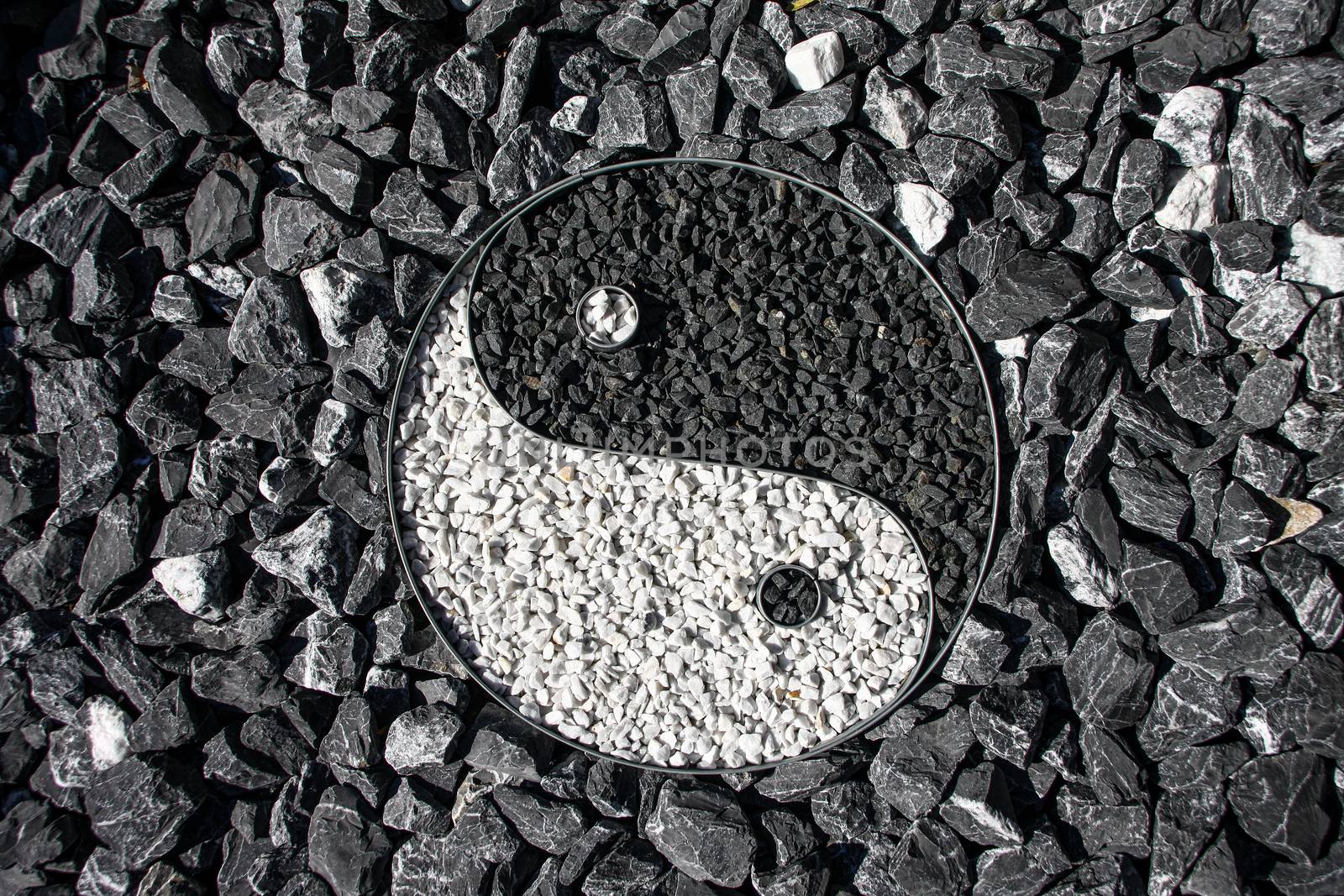 Yin and Yang designed with stone in a outdoor garden surrounding the sign