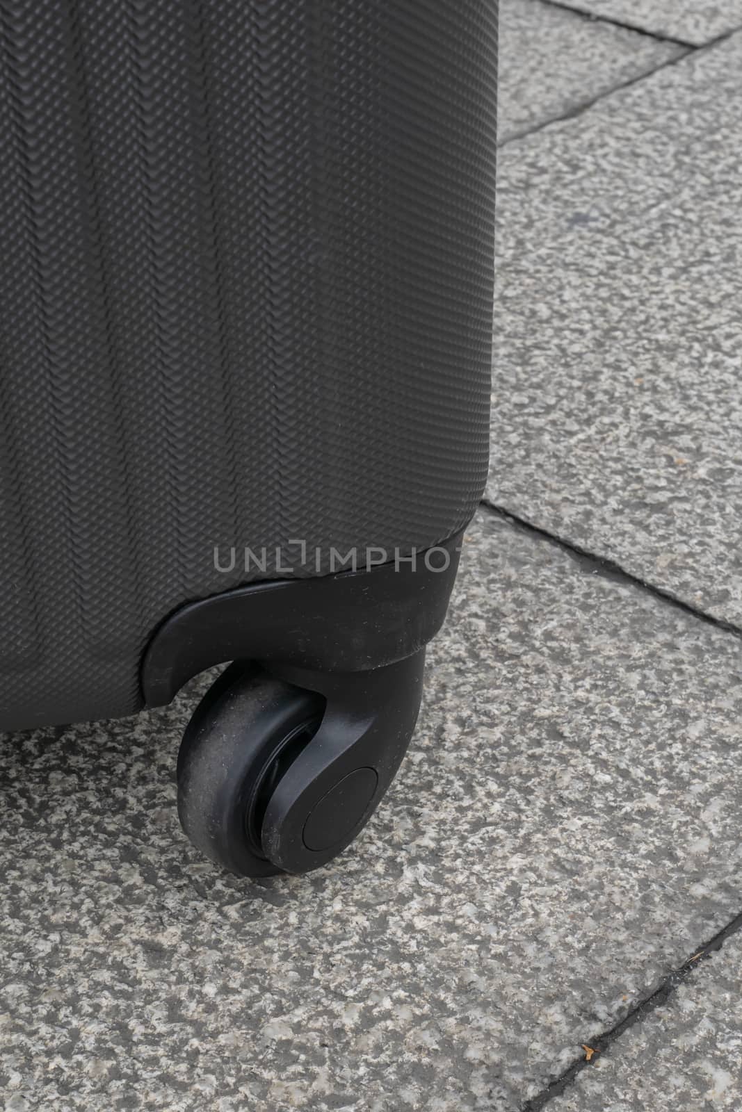 The close up of Wheeled luggage travel bag on concrete texture ground.