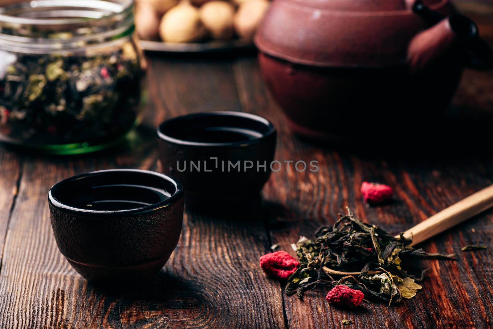 Tea bowls with teapot and spoonful of raspberry herbal tea by Seva_blsv