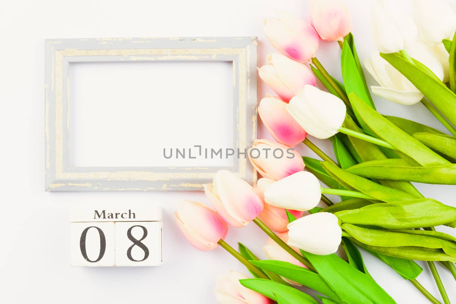 Happy Women's Day, Mother's Day and Valentine's Day concept. top view flat lay Tulip flower and photo frame on white background, copy space for your text