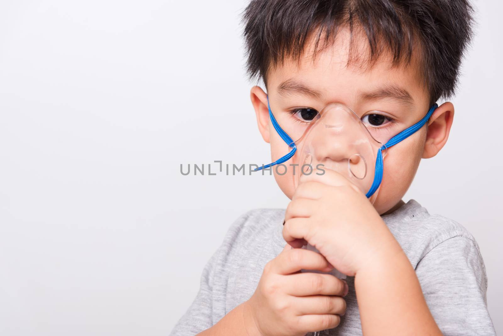 Closeup Asian face, Little children boy sick he using steam inhaler nebulizer mask inhalation oneself on white background, health medical care