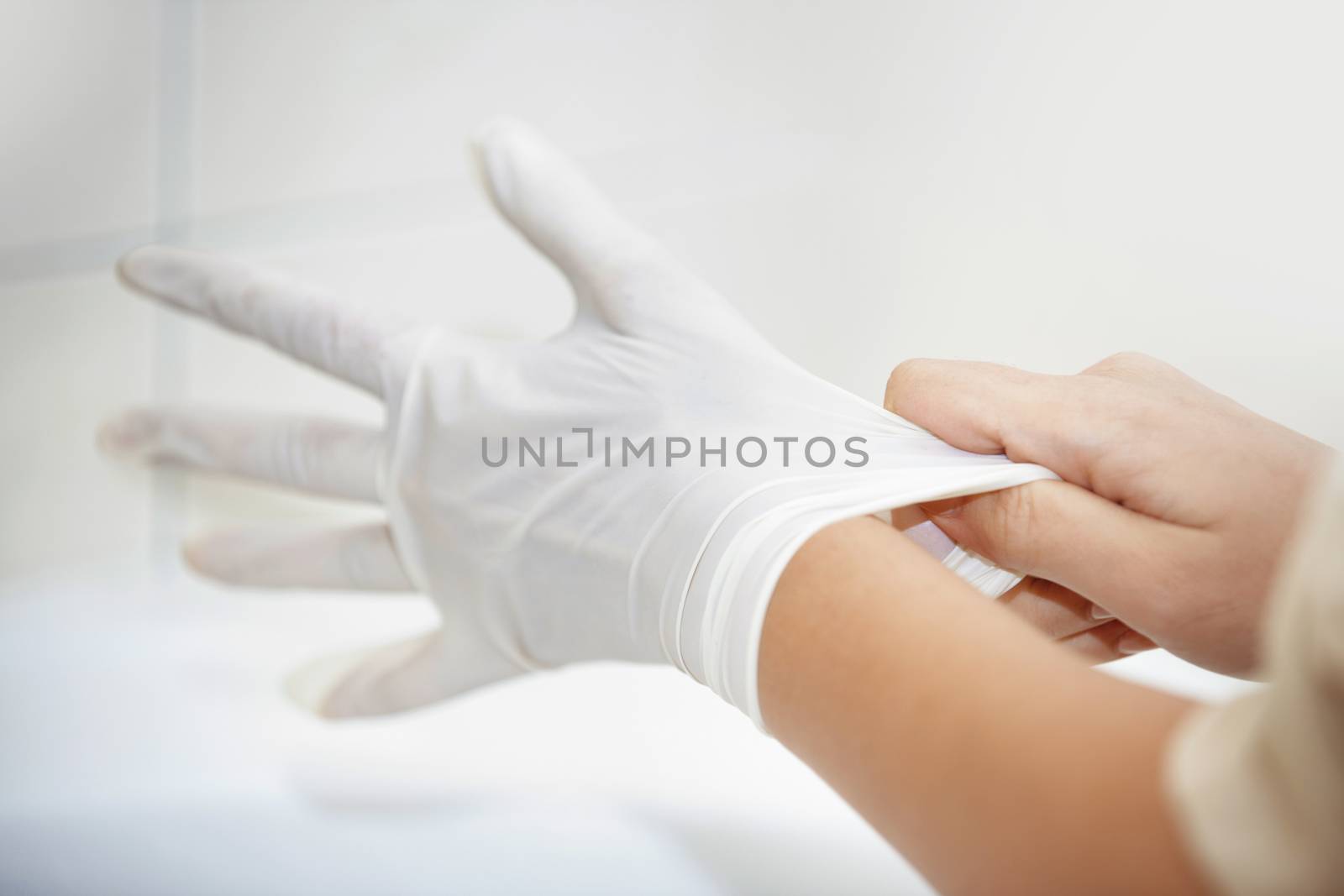 Hands of human taking on rubber gloves