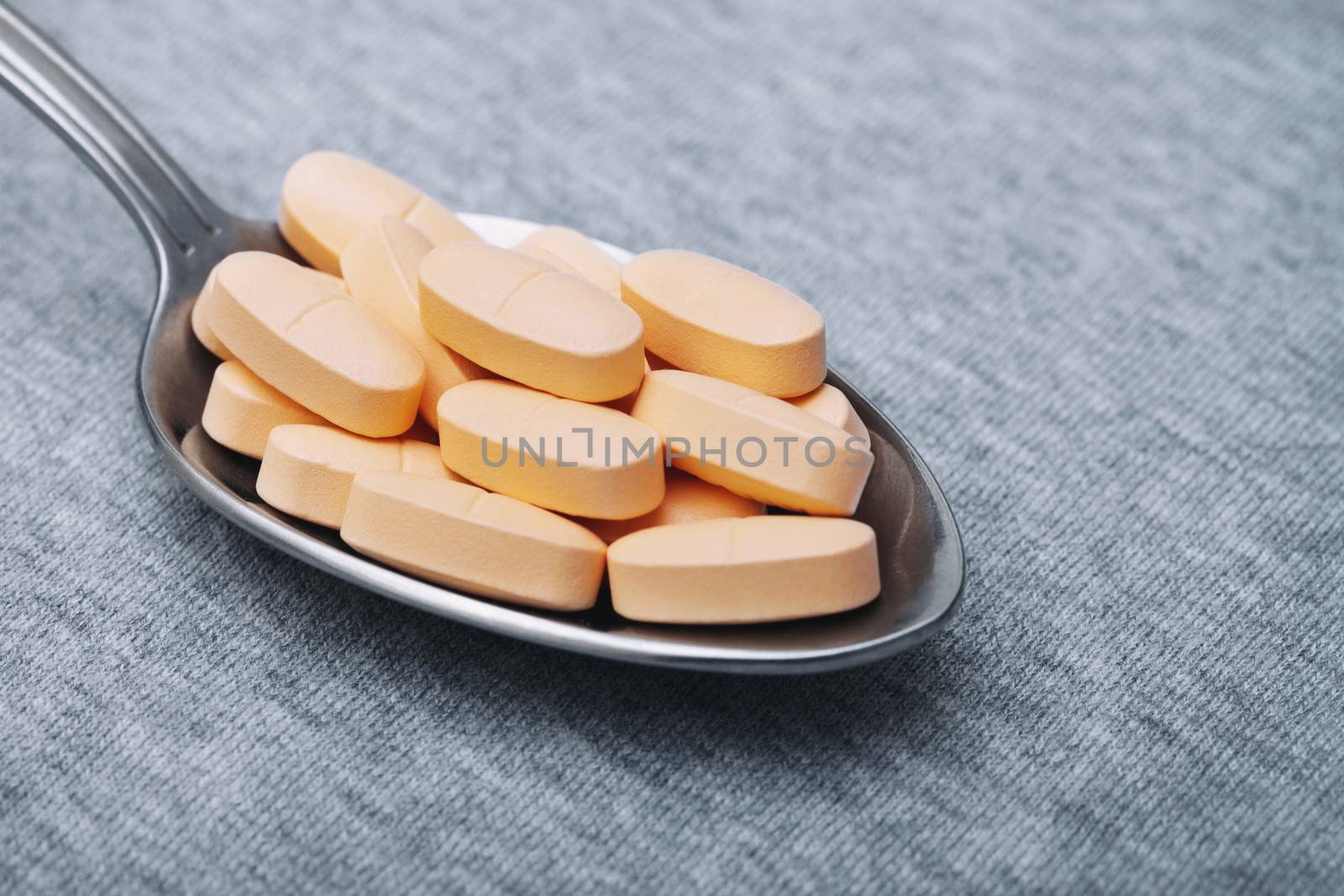 Medical pills on a metal spoon. Close-up photo by Novic