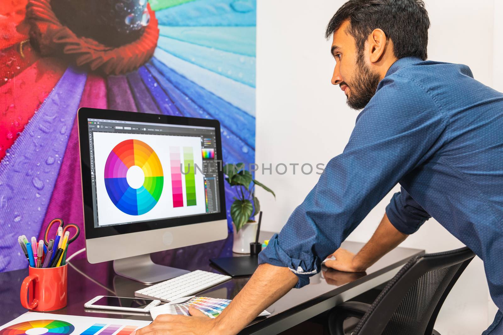 Concentrated young businessman working and standing in front of computer in office