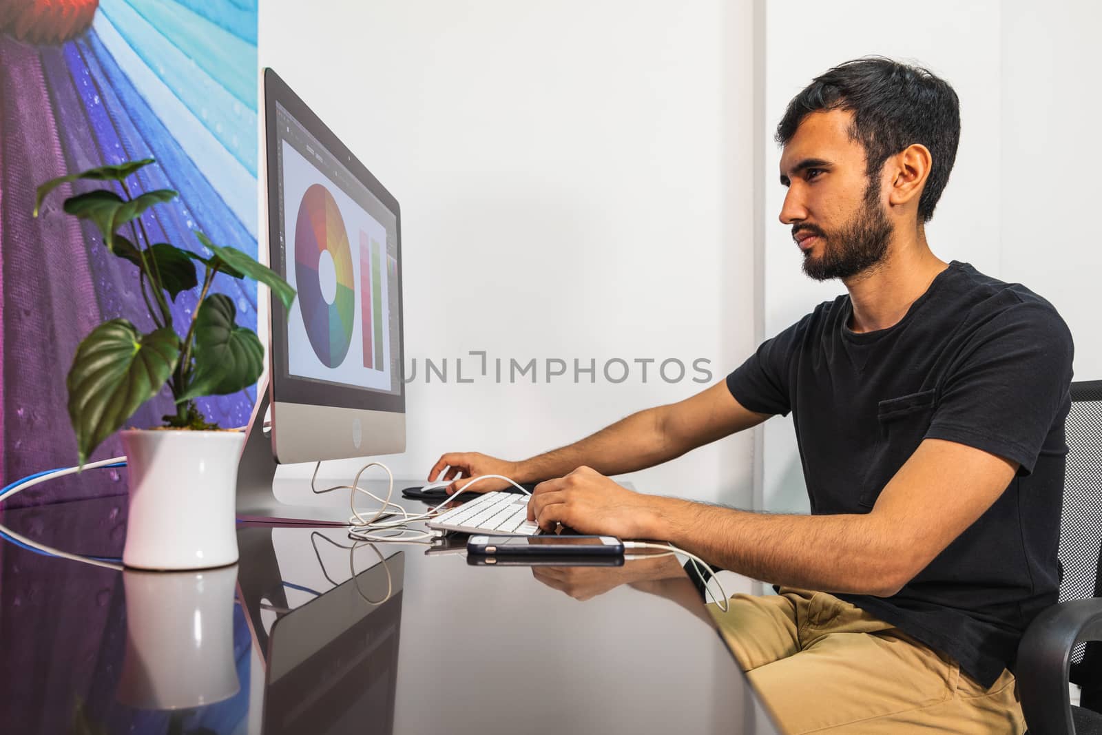 Businessman In black Shirt Sitting At Work Desk Looking At Monitor