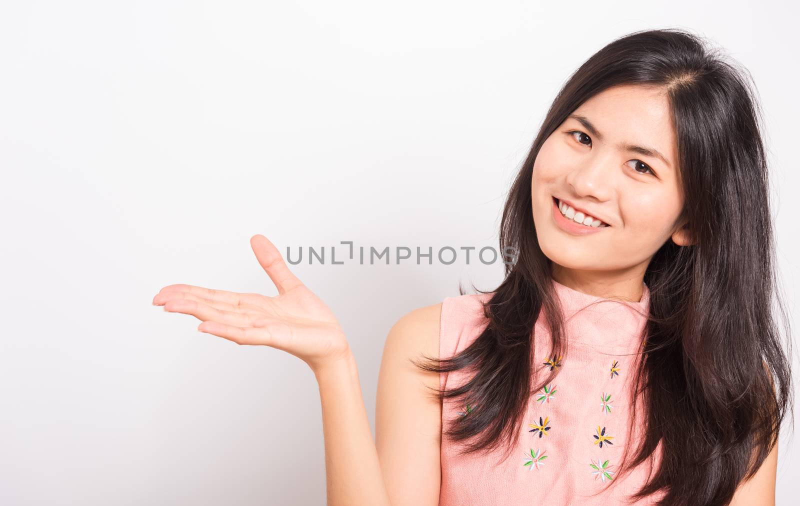 Young woman standing showing hand presenting product by Sorapop