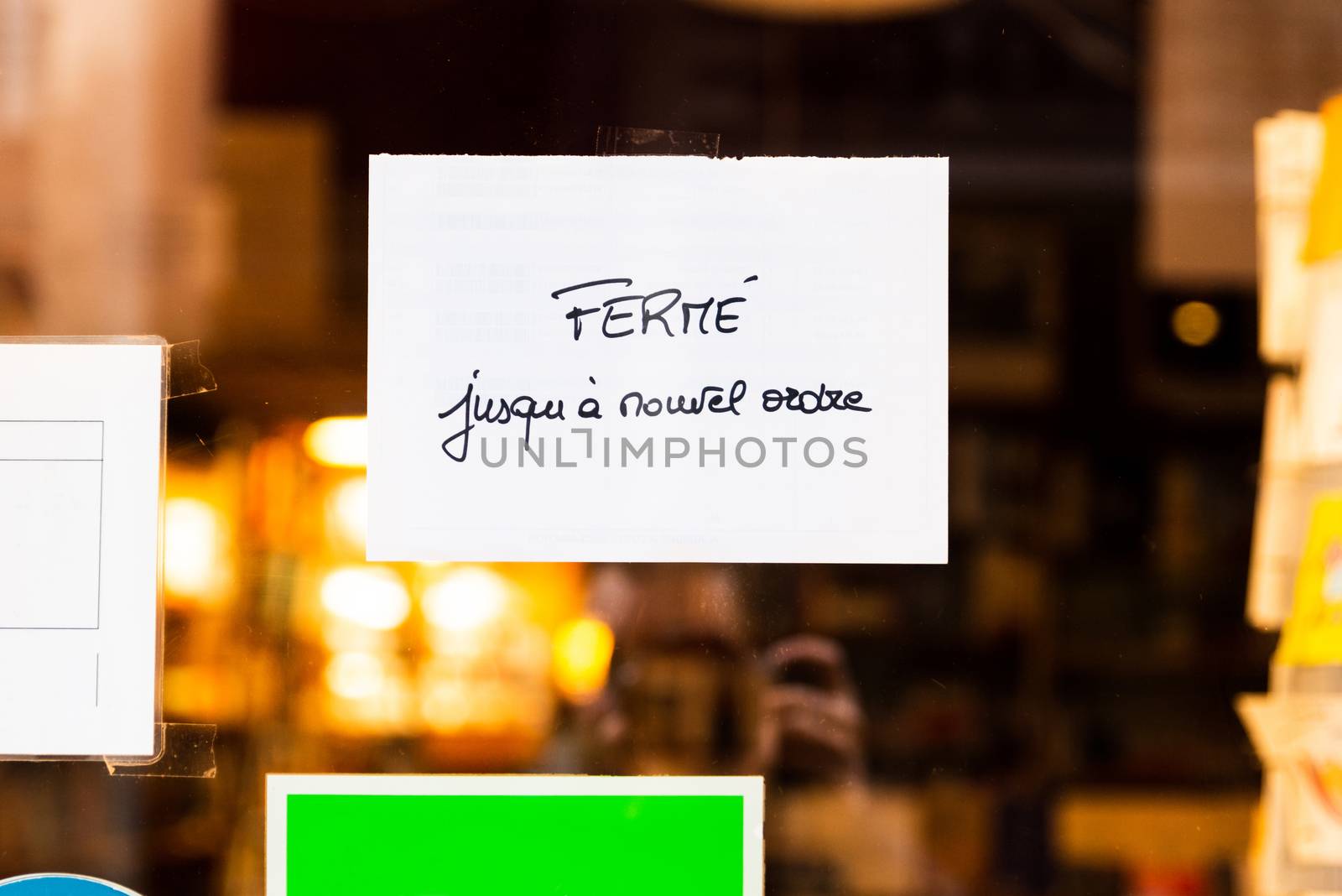 Handwritten french sign on a bookstore window reads closed until further notice, in Bayonne, France