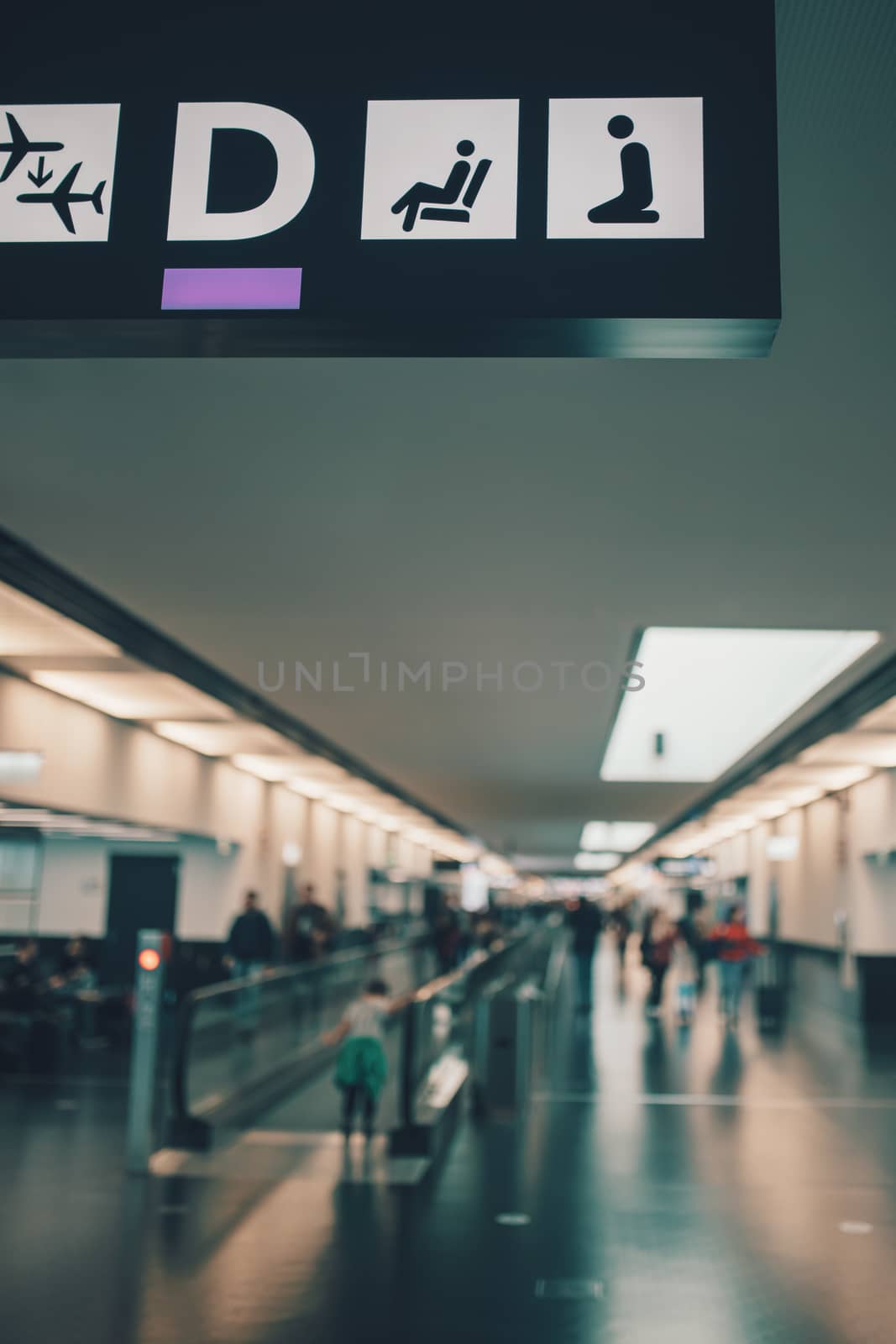 Peoples walking and carries luggage in Vienna airport terminal. Shallow focus, blurry background. Travel concept