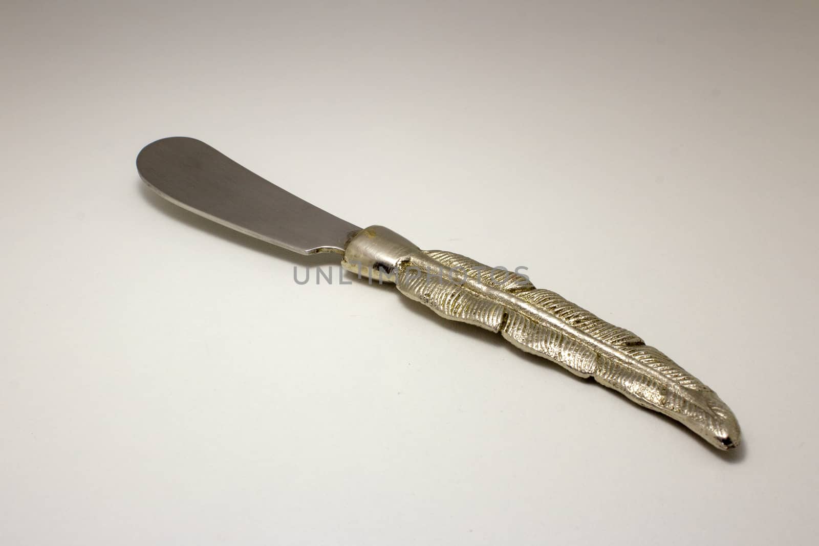 Butter knife with a handle shaped like a metal feather