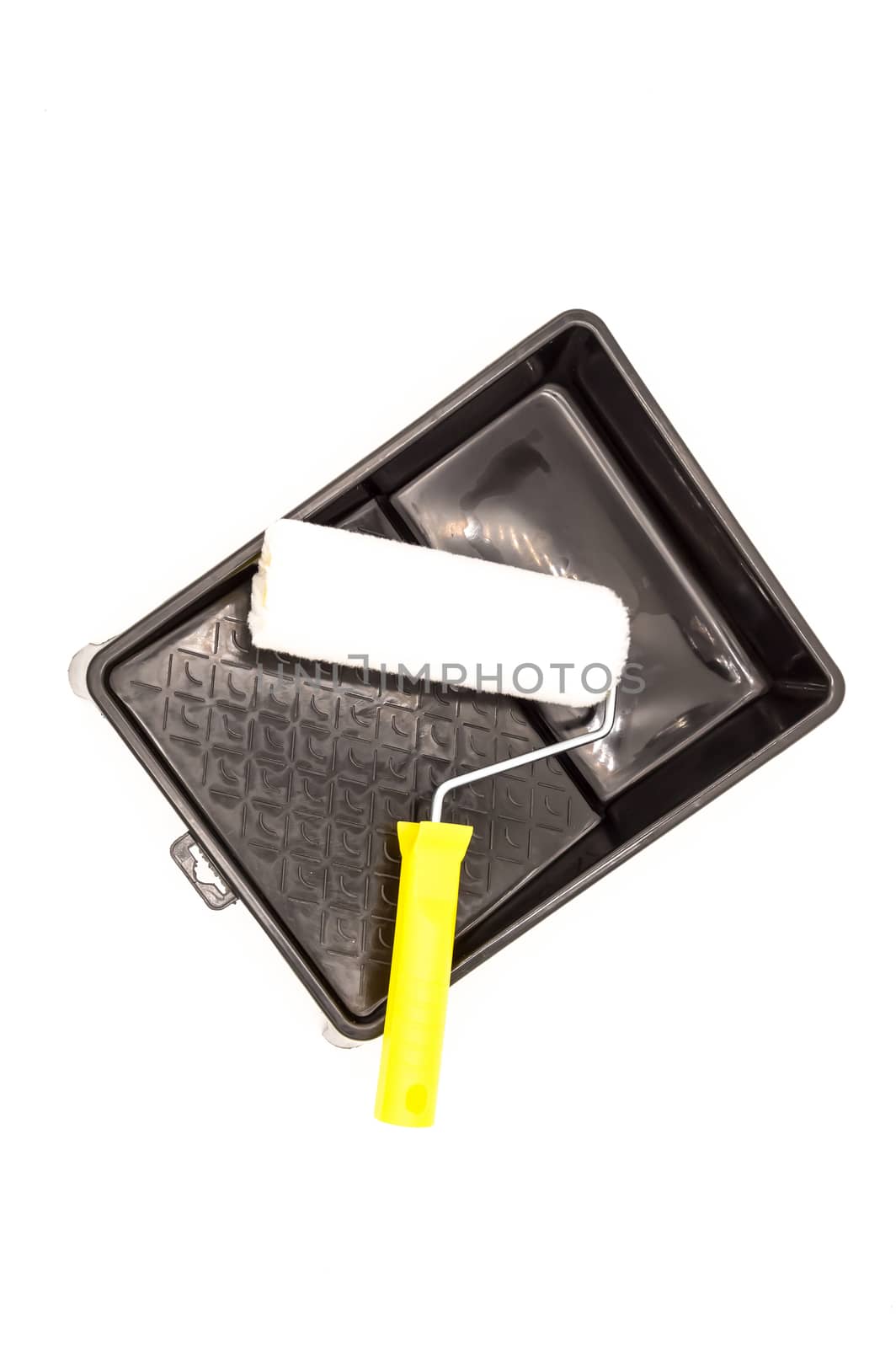 A clean paint roller rests on a black paint tray. Isolated on white background with clipping path.