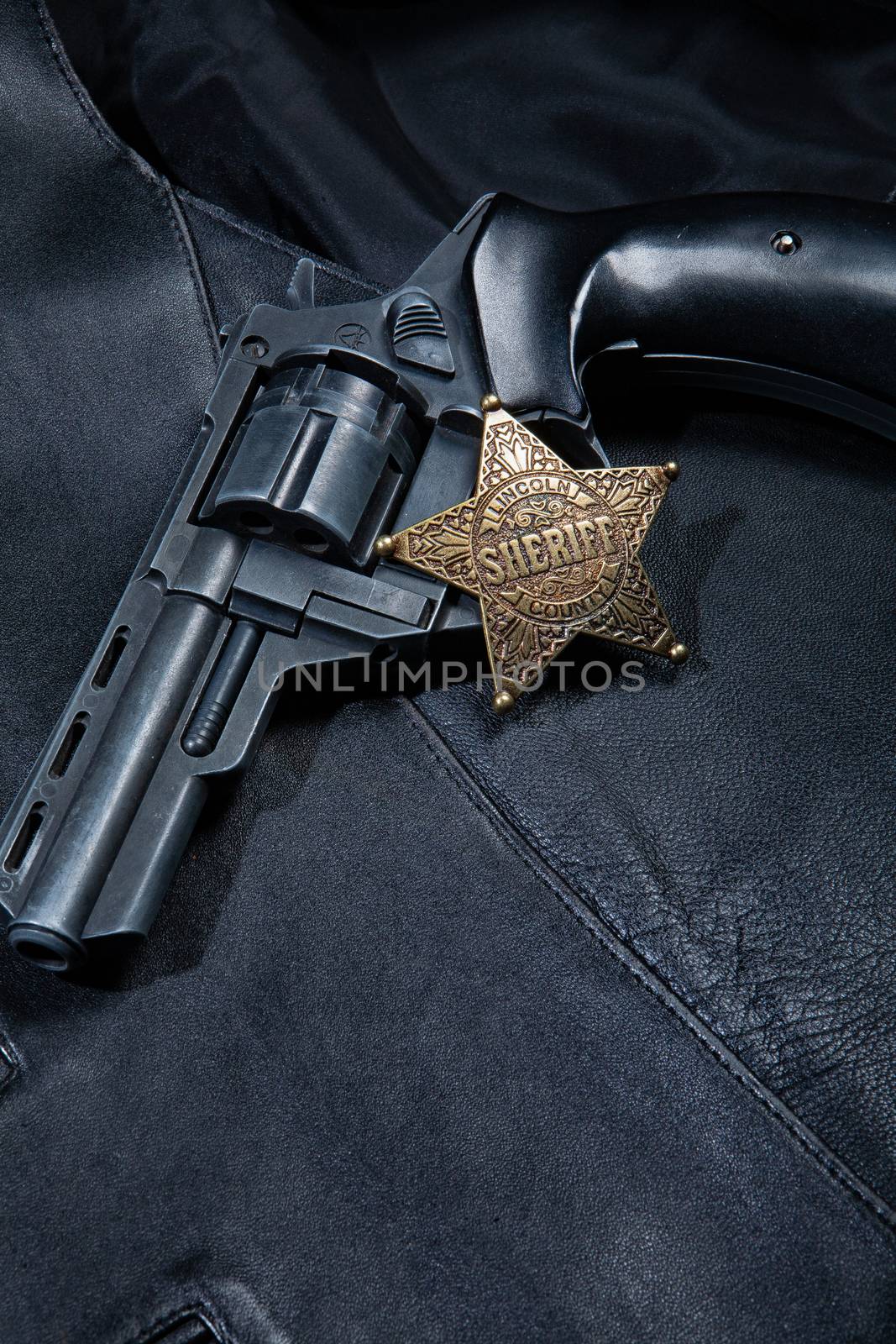 Star badge and revolver on a studio background
