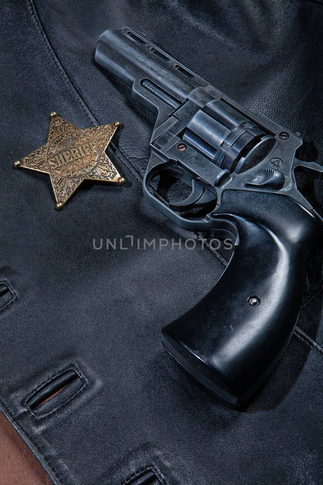 Star badge and revolver on a studio background