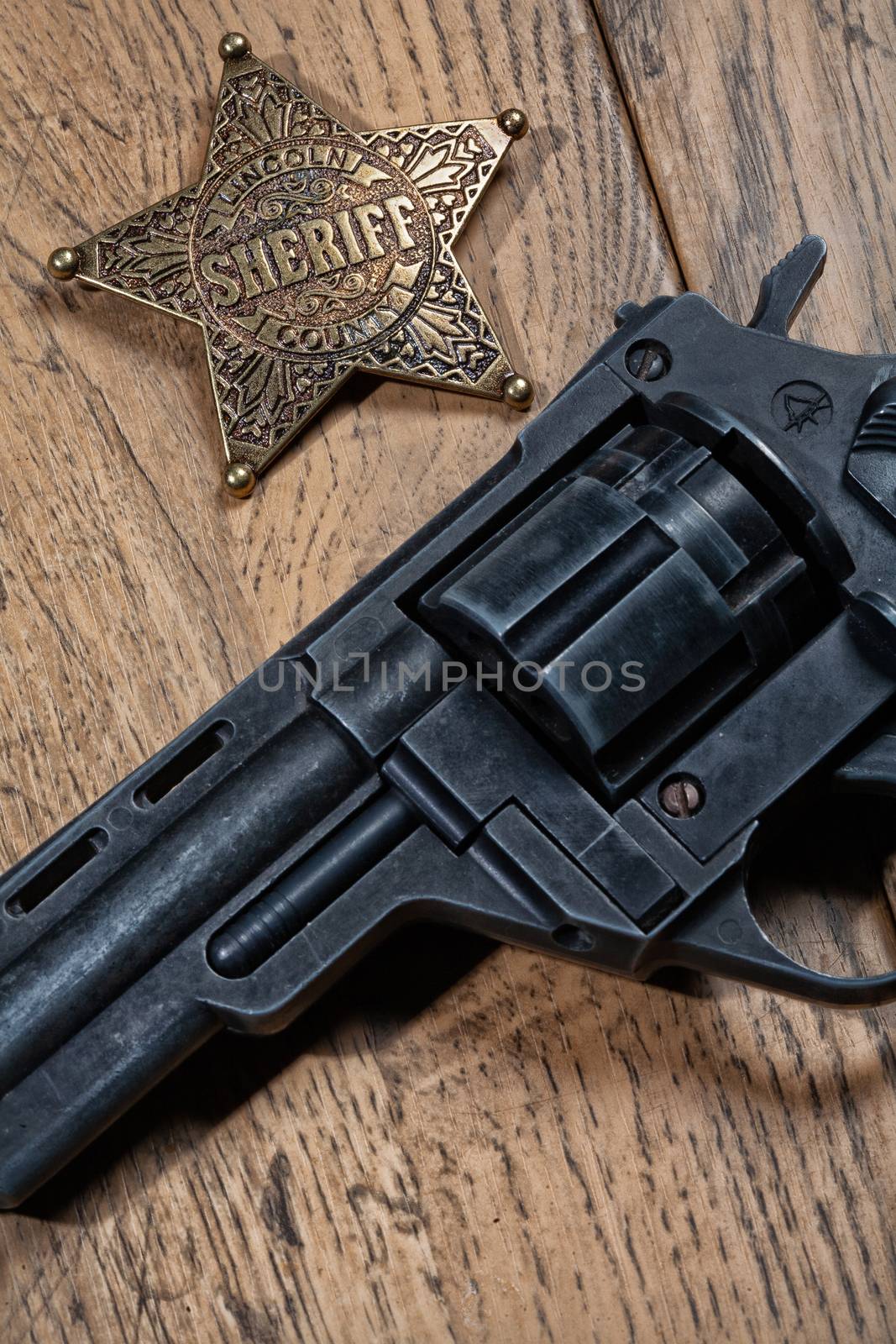Shariff'w star and revolver on a wooden background