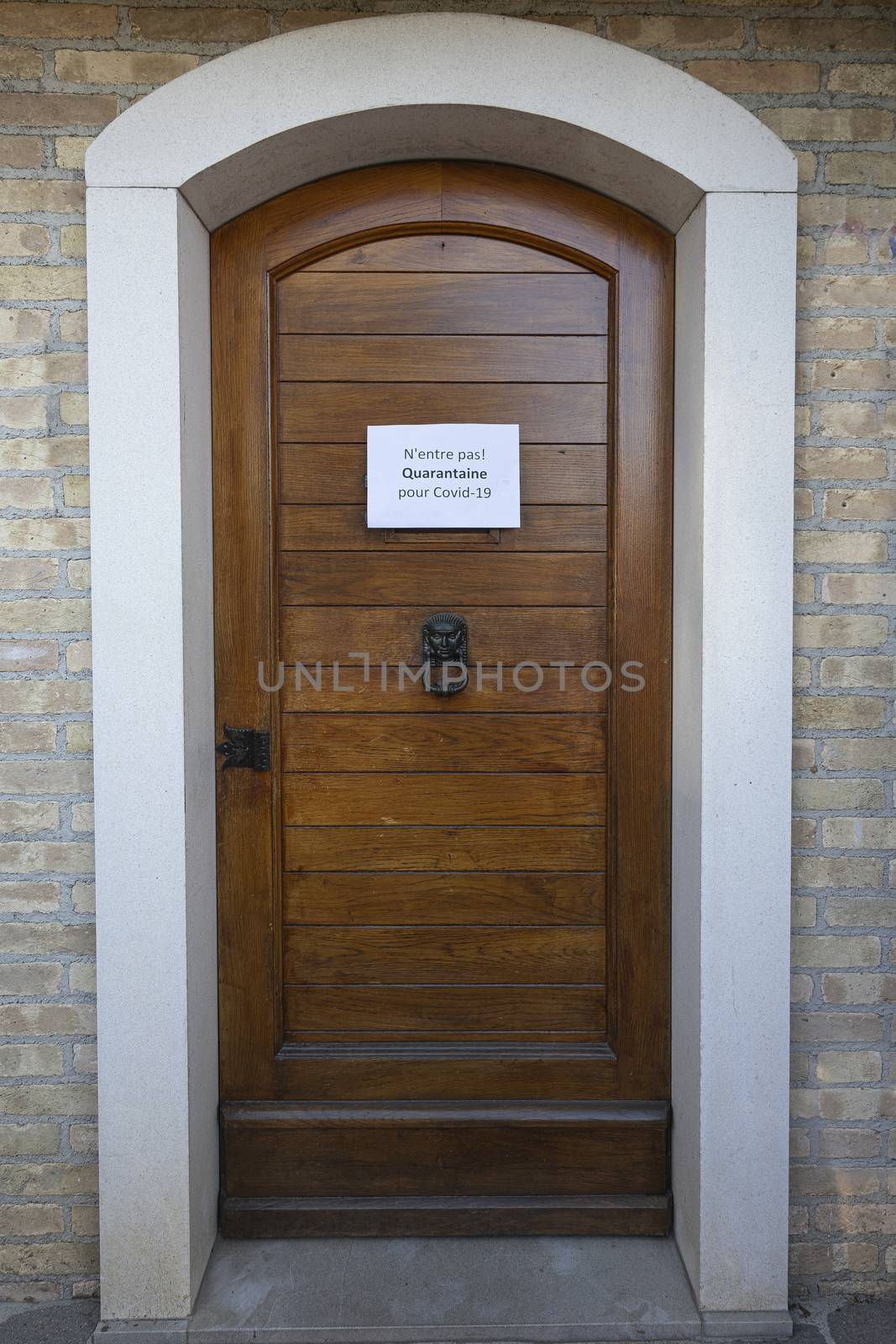 The sign Quarantine  for Covid-19 virus in French language on a wooden entrance door