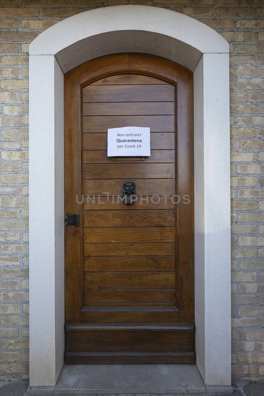 The sign No entry Quarantine  for Covid-19 virus in Italian language on a wooden entrance door