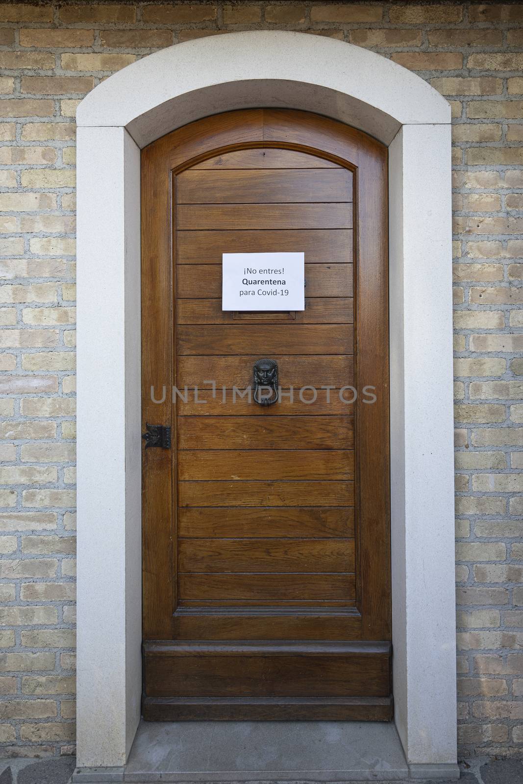 The sign Quarantine  for Covid-19 virus in spanish language on a wooden entrance door