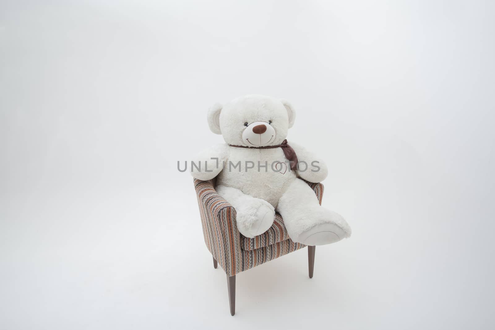 Teddy bear and classic soft chair on white blackground