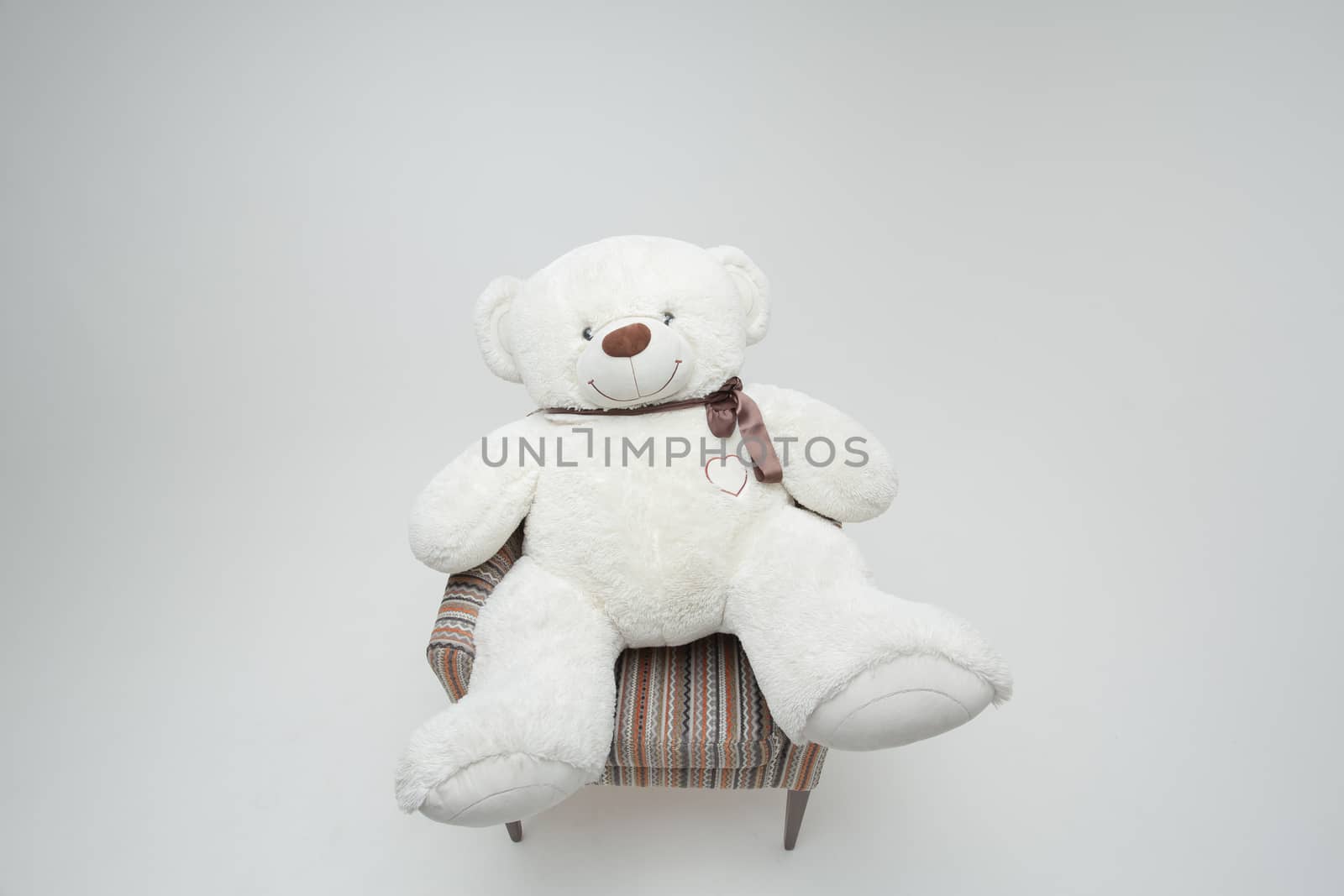 Teddy bear and classic soft chair on white blackground