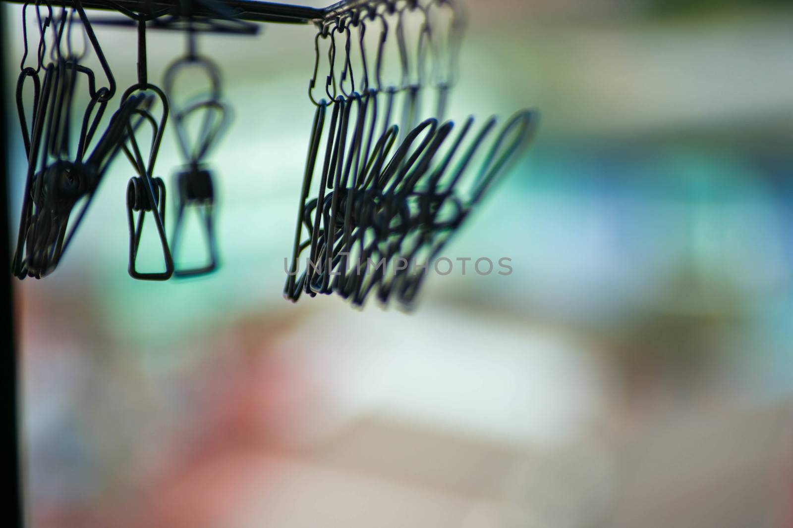 The Dark Stainless steel clothespin in blur natural abstract background. Clothing, fabric.