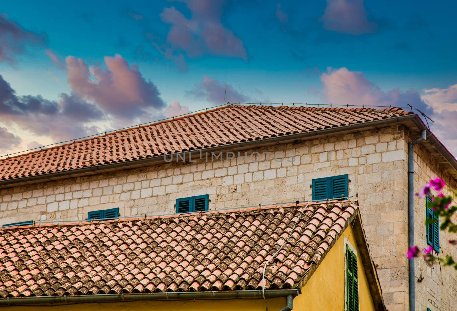 Two old stone buildings in Kotor, Montenegro with clay pipe roofs