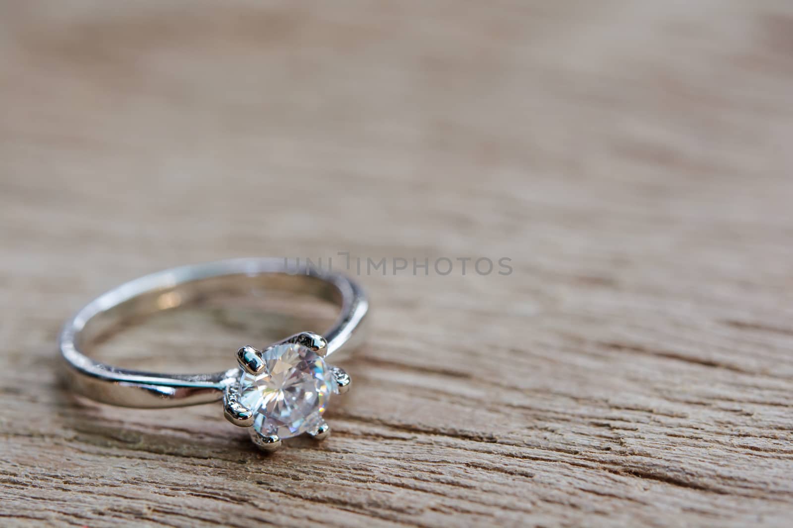 Diamond ring, wedding ring on plank wooden with copy space 
 by sunnygb5