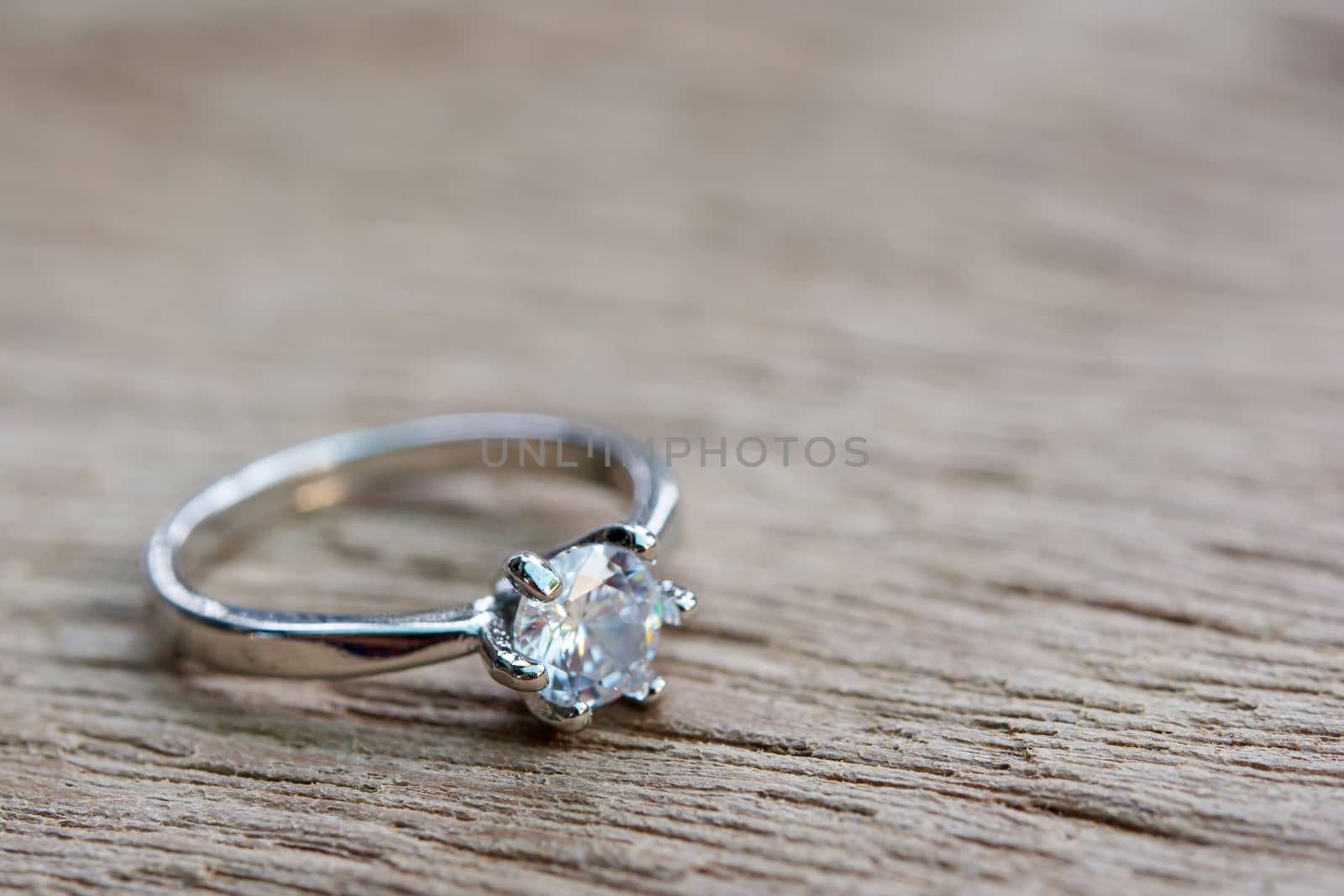 Diamond ring, wedding ring on plank wooden with copy space 
