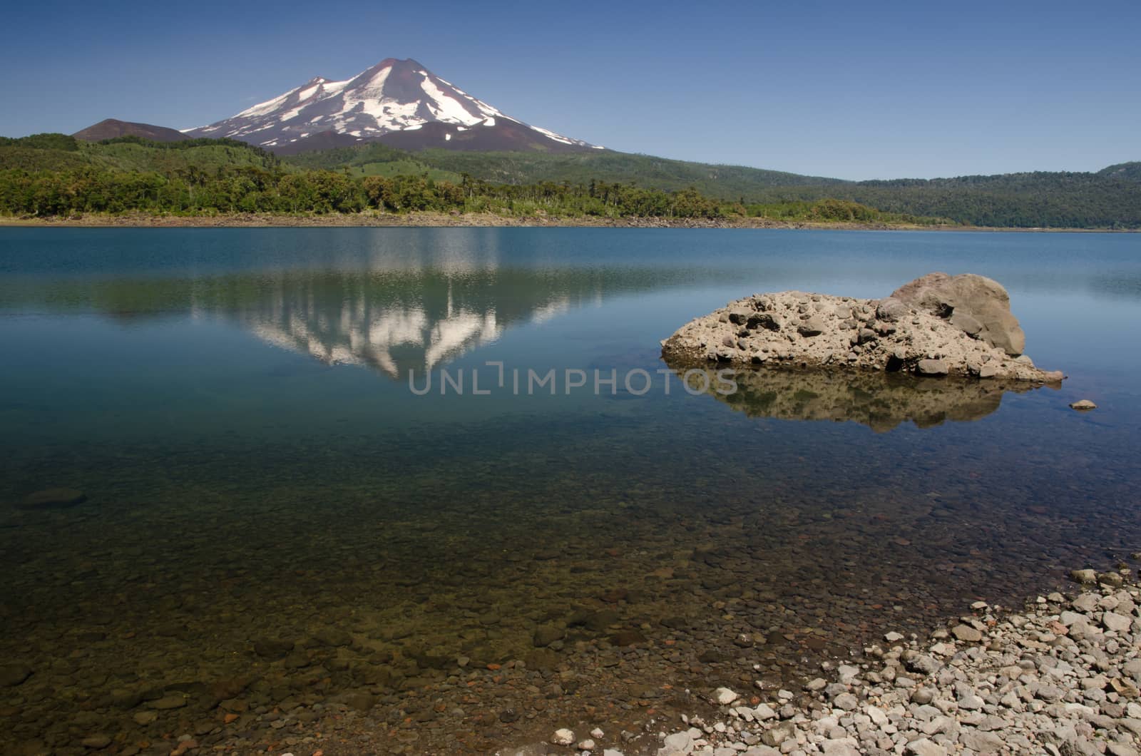 Llaima volcano reflected on the Conguillio lake. by VictorSuarez