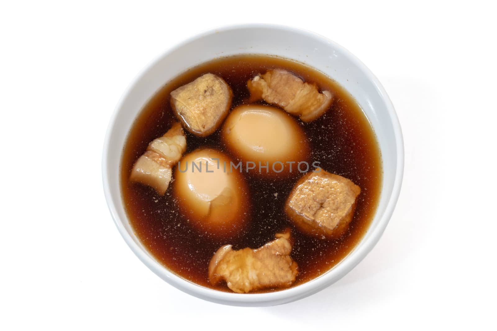 The close up of Thai egg and pork in sweet brown sauce food in white bowl on white background.