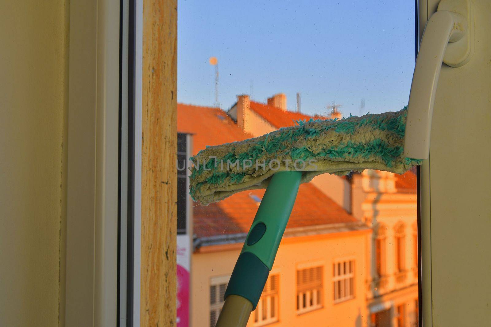 Cleaning windows with a squeegee. Cleaning concept. Washing window, close up. Looking through window