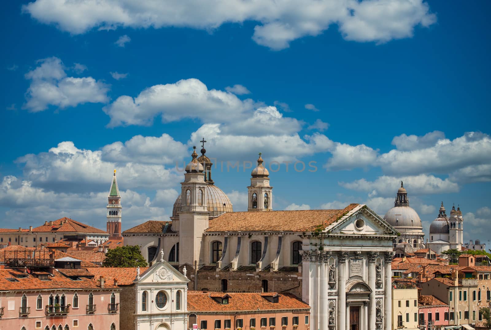 Red tile roofs and church domes under sky in Venice, Italy