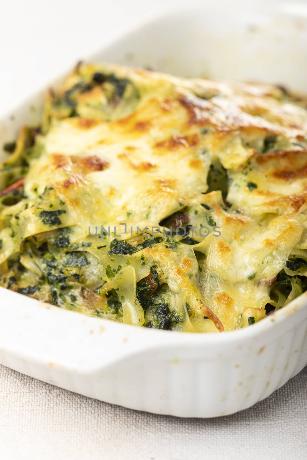 baked pasta with spinach in a casserole by bernjuer