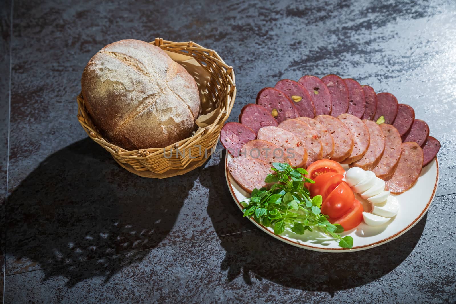 Slicing different types of sausages on a plate with herbs and vegetables by sveter