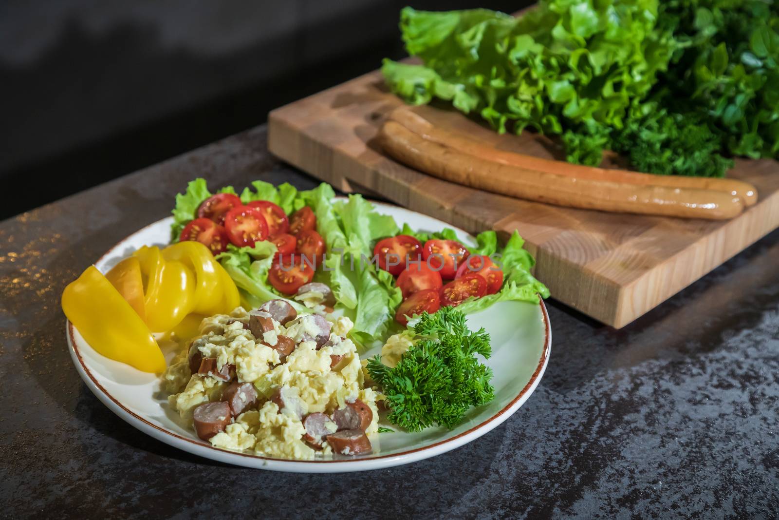 Omelet with herbs and vegetables on a gray table in the kitchen