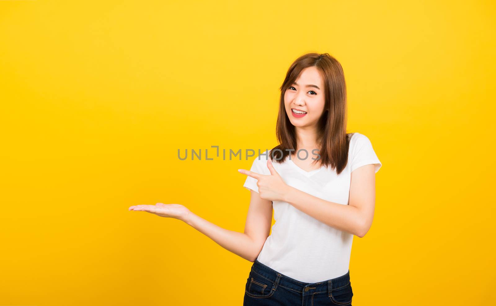 woman teen standing holding something on palm and point away sid by Sorapop