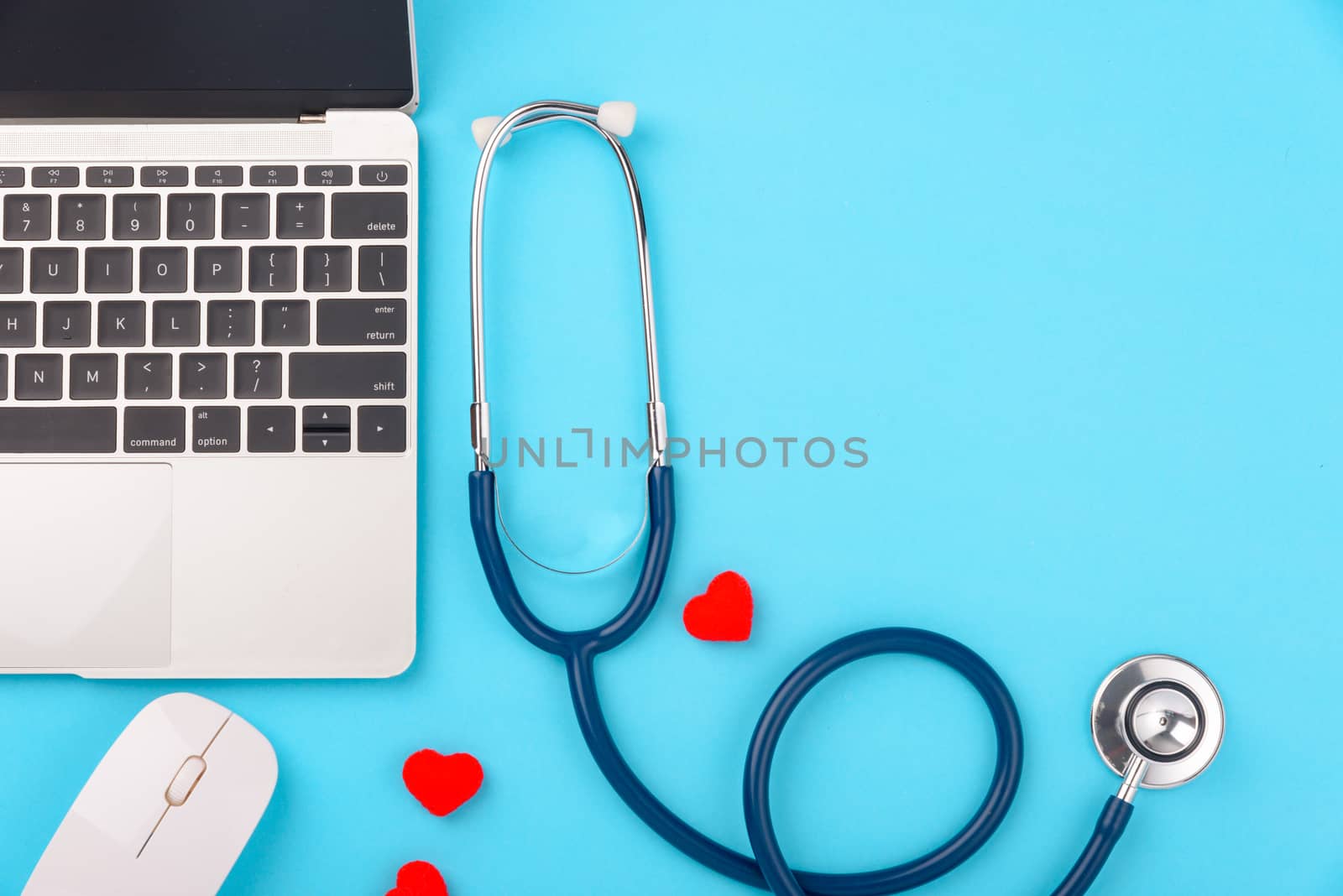 Doctor's Day concept, flat lay top view, stethoscope with laptop computer diagnosis of heart disease on blue background with copy space for text
