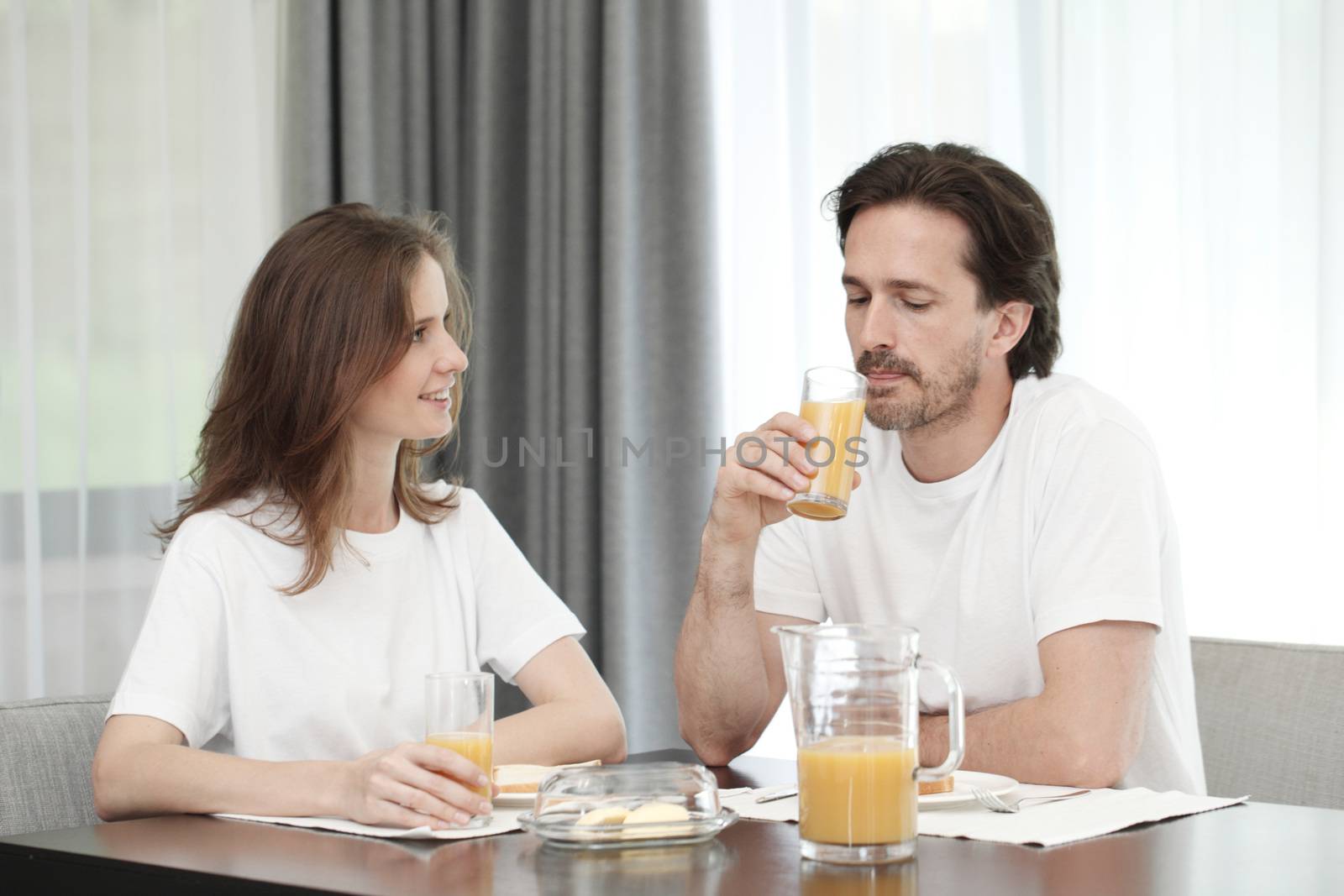 Happy couple eats breakfast together by ALotOfPeople
