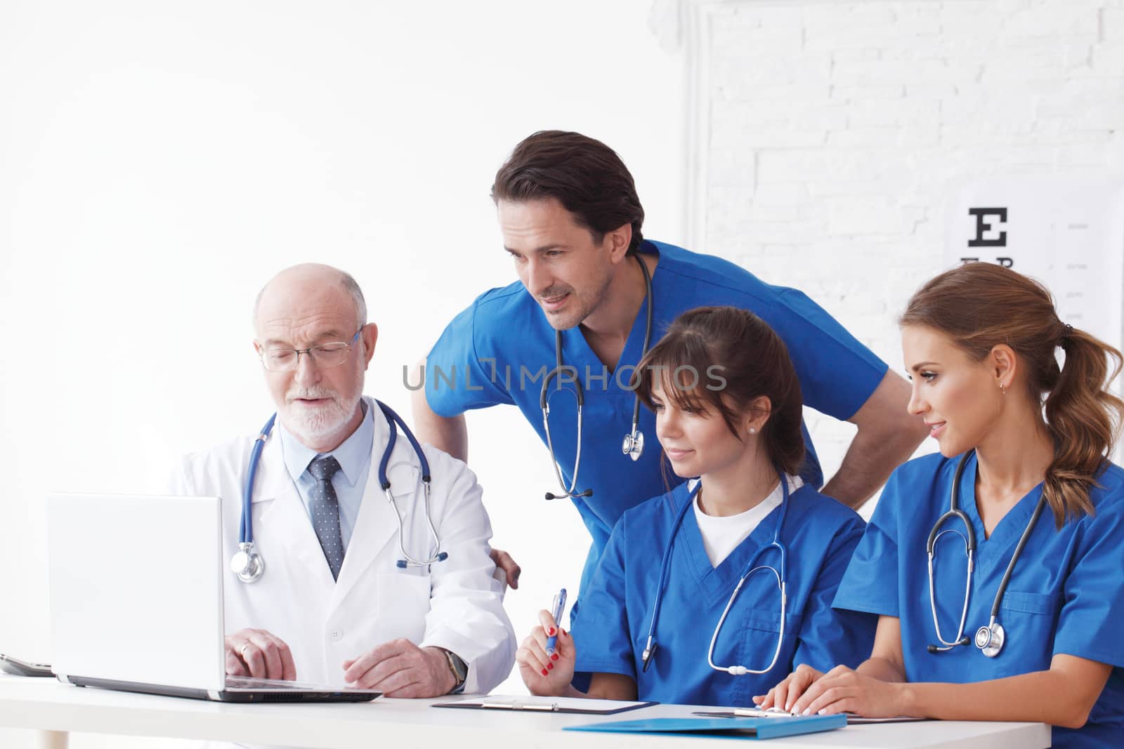 Medical doctors team using laptop at consultation in clinical office
