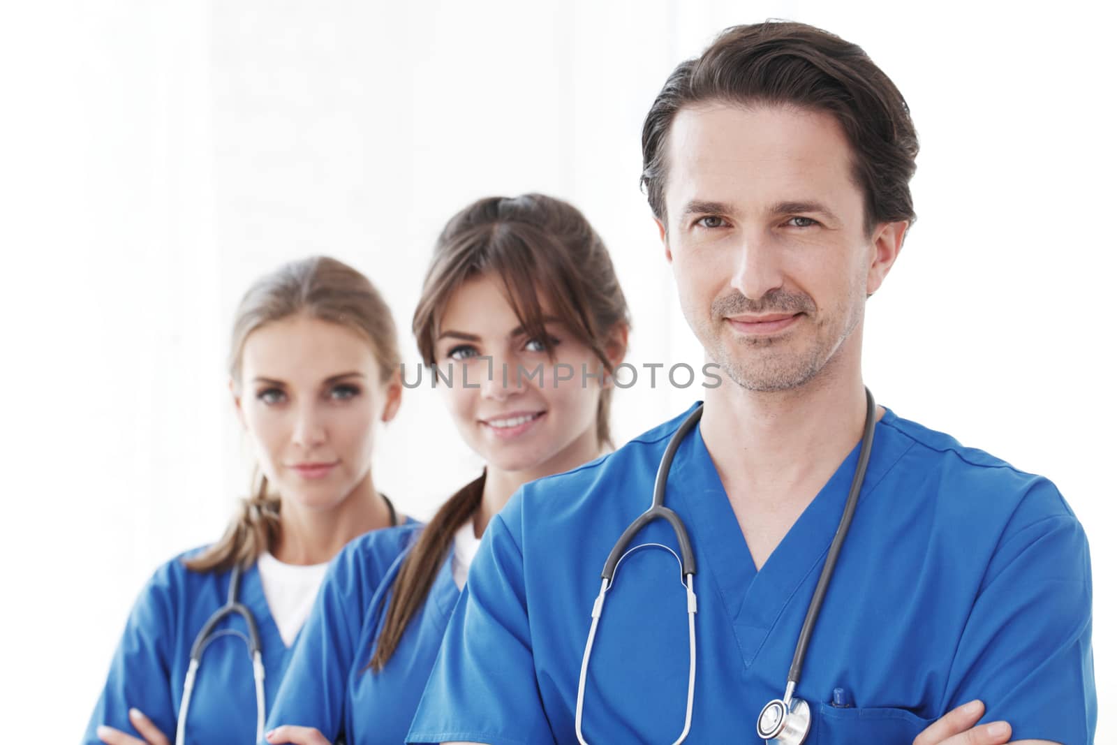 Portrait of group of smiling hospital colleagues standing together isolated on white background
