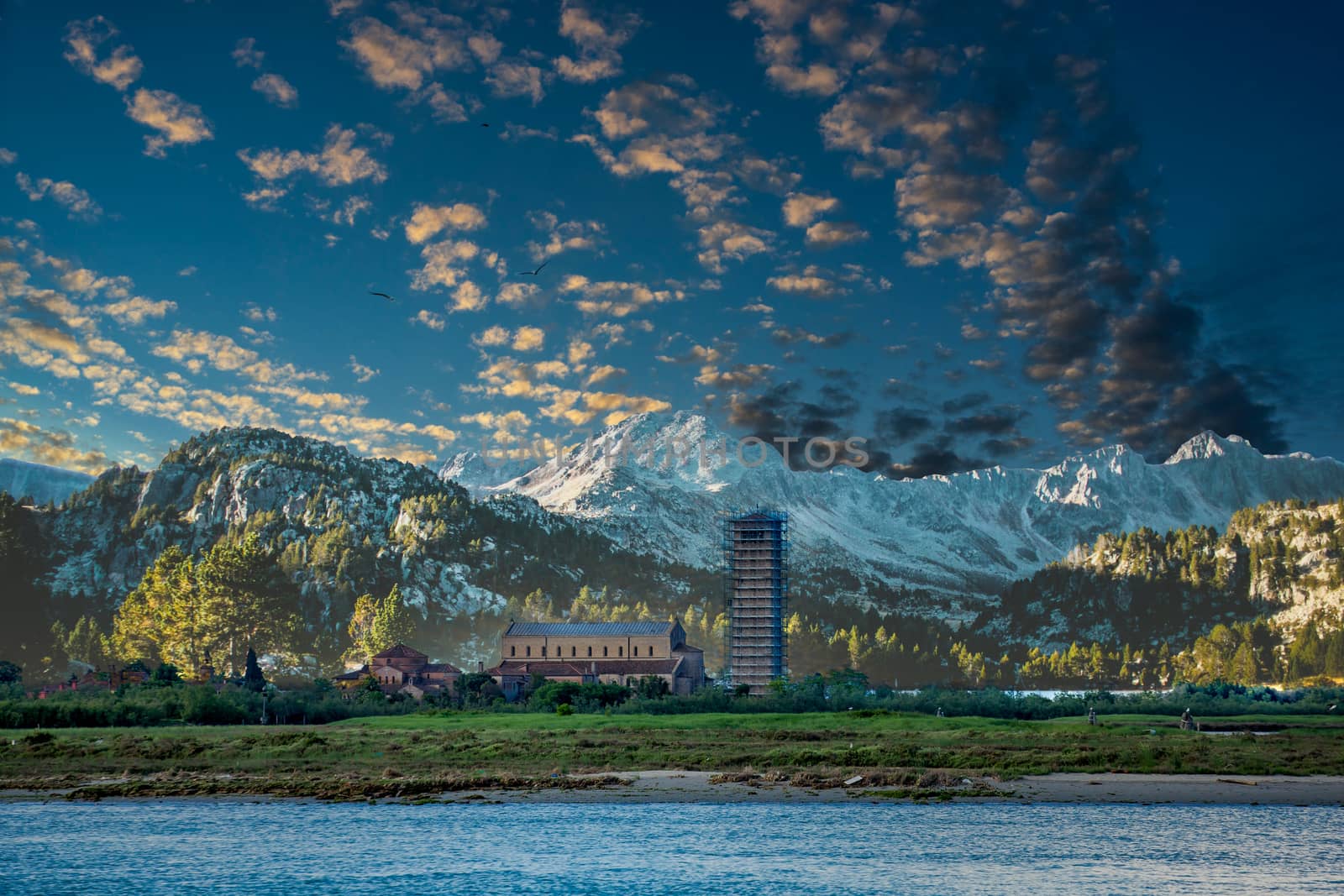 Old church in field by Mountains with bell tower covered in scaffolding