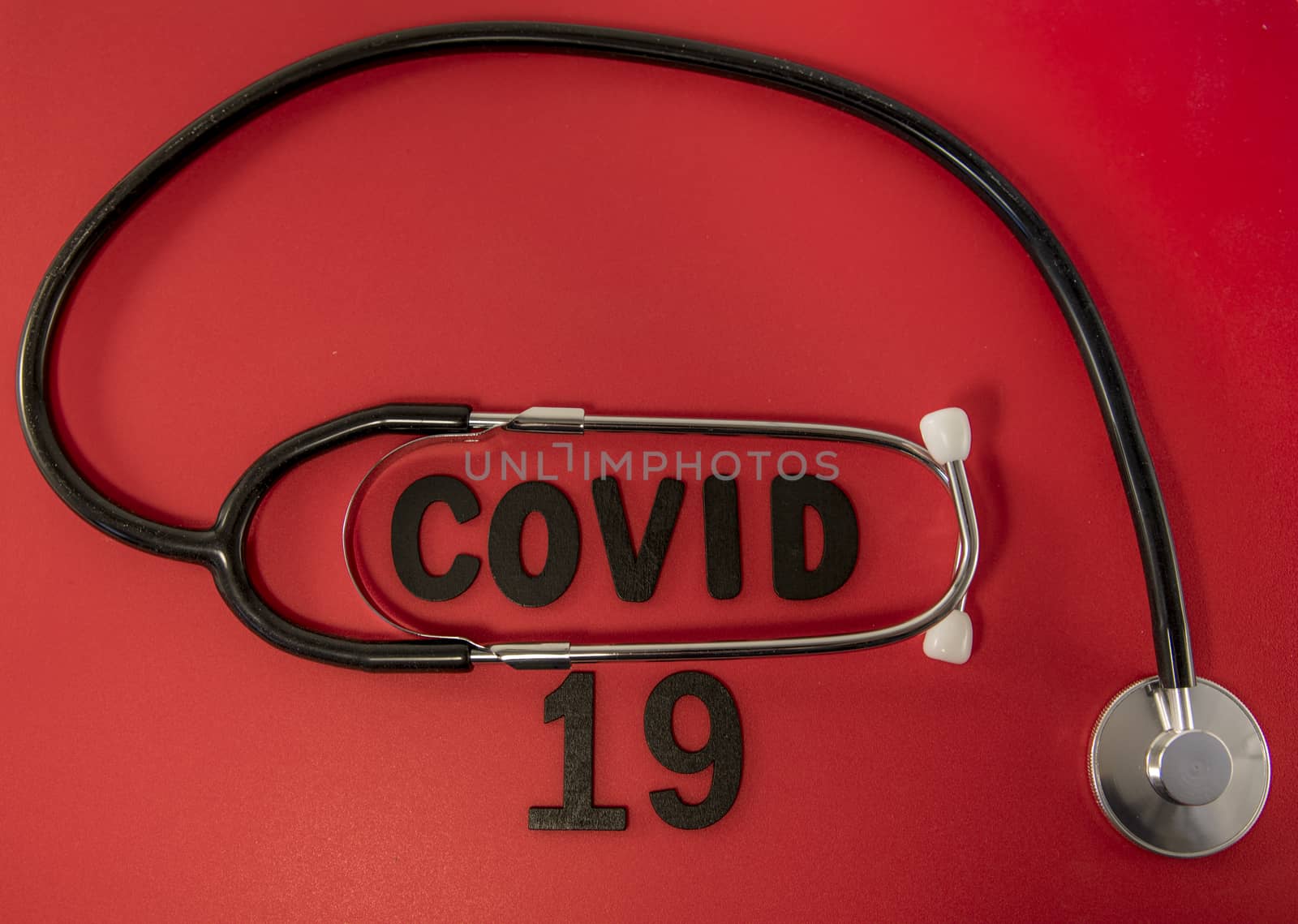 Covid 19 virus conceptual image with text in black and red and stethoscope