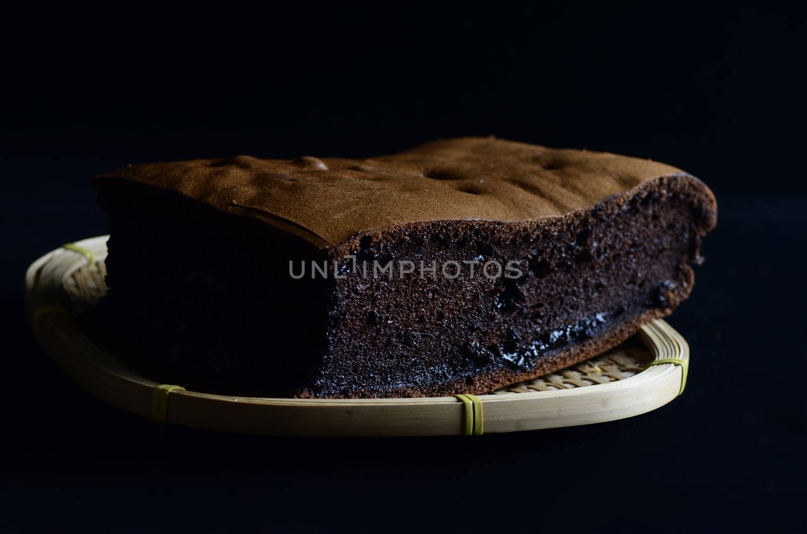 chocolate  sponge cake  on wooden basket isolated on black background