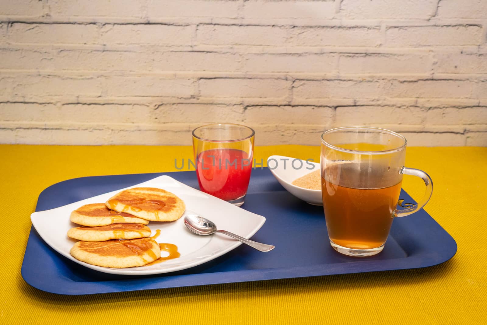 Breakfast with maple syrup pancakes, hot tea and blood orange juice