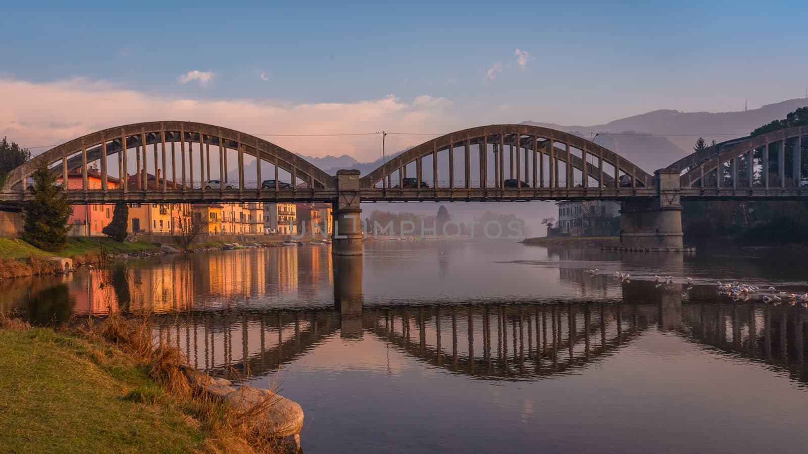 Morning landscape on the Adda river with arch bridge