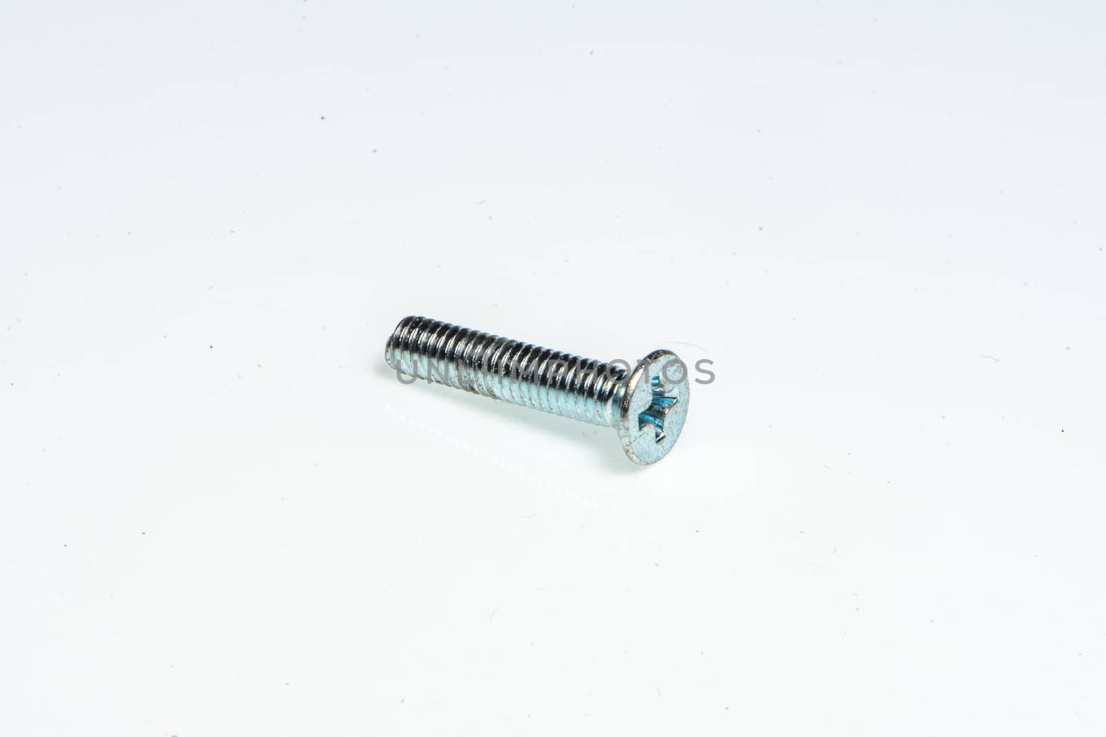 Detail of a small steel screw by brambillasimone