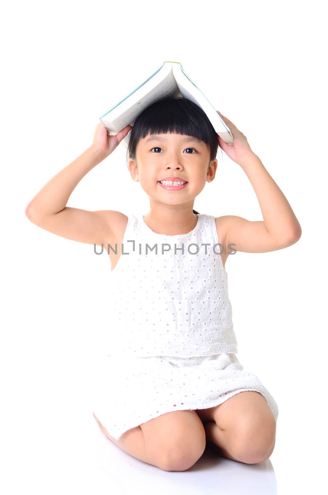 Lovely asian girl sitting on the floor, holding a book