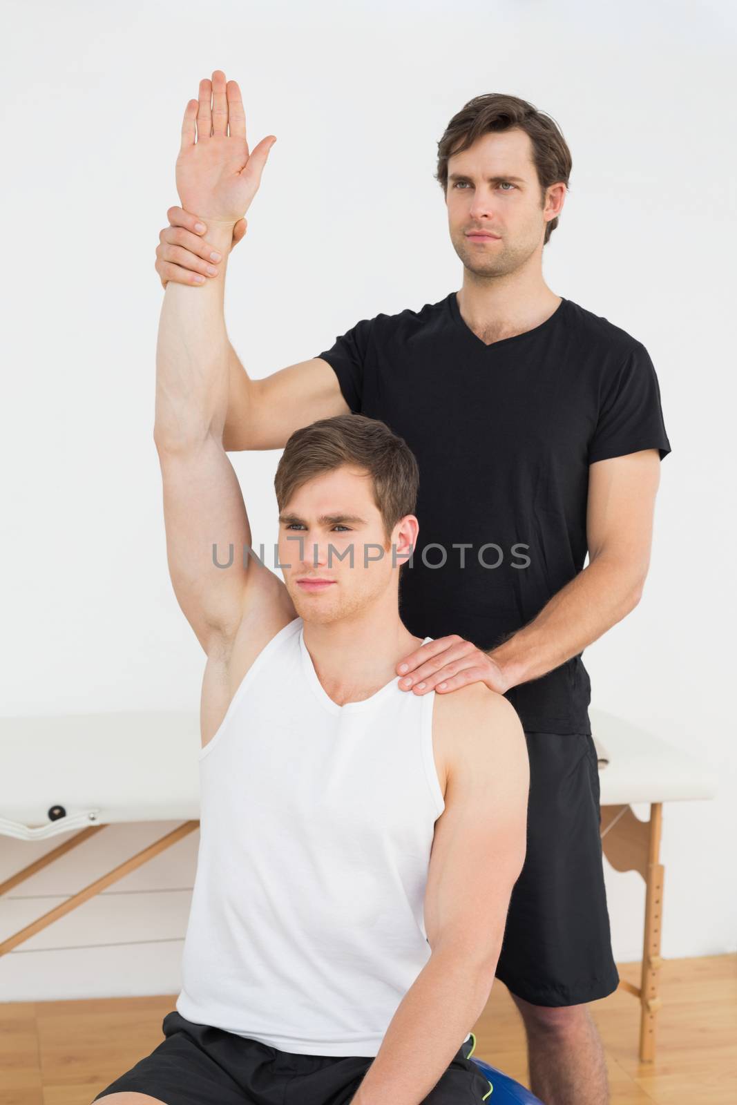 Man working with a physical therapist by Wavebreakmedia