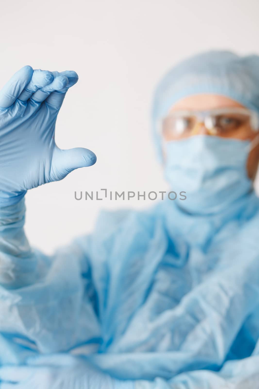 Close up of doctor hand holding. Mock up. Medical equipment. A doctor wearing personal protective equipment including mask, goggle, and suit to protect COVID-19 coronavirus infection. by Denys_N